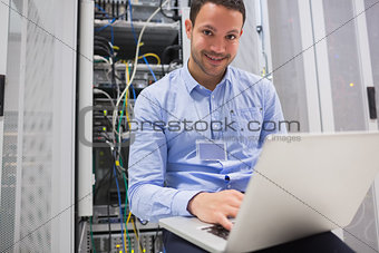 Happy man using laptop to check servers
