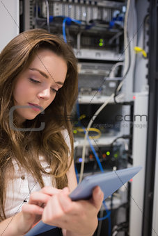 Woman working on servers checking tablet pc