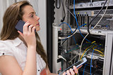 Woman working on servers with tablet pc on the phone