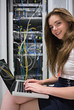 Woman with laptop working on servers