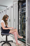 Woman working on laptop with servers