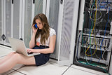 Woman checking the servers with laptop and talking on phone