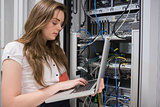 Woman using laptop to work on servers