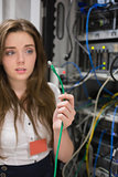 Woman holding green wire of server and looking confused