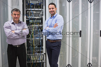 Two smiling men standing in front of servers
