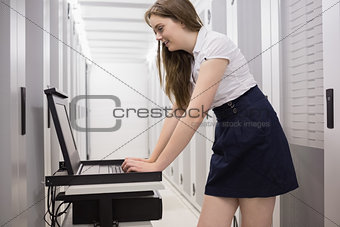 Woman doing maintenance on servers with a laptop