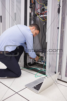 Man doing maintenance and fixing wires on server