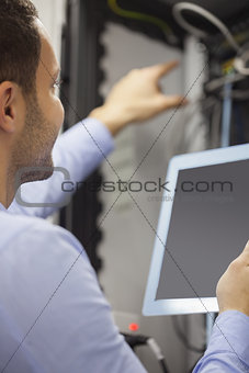 Man fixing wires with tablet pc