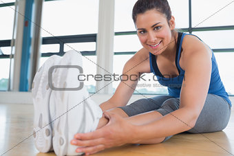 Smiling woman stretching legs