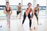 Smiling people lifting weights in aerobics class