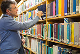 Man taking a book from the shelves