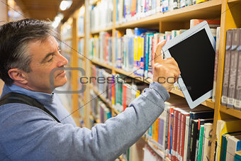 Man taking a tablet pc from the shelves