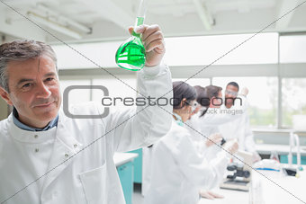 Chemist happily holding beaker