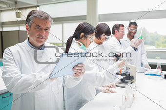 Smiling chemist using tablet pc