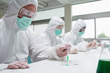 Chemists in protective suits working
