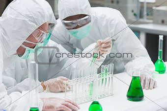 Two chemists experimenting with the green liquid