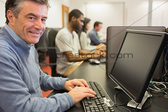 Smiling man sitting in front of the computer