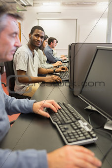 Smiling young man at computer class