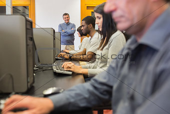 Teacher standing at front of computer class