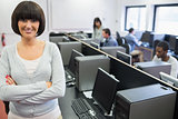 Student standing at front of computer class with arms crossed
