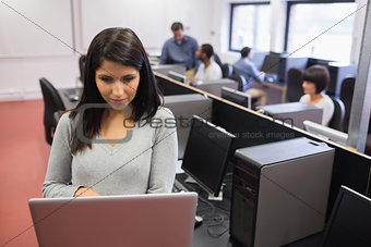 Woman typing on laptop in class