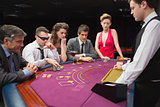 People sitting at table playing poker