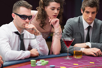 Men and woman sitting at poker table
