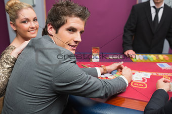 Couple smiling as man is taking his winnings
