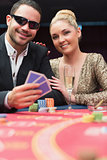 Couple sitting at the poker table smiling
