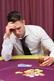 Man holding whiskey glass at poker table