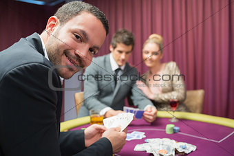 Man smiling and looking up from poker game
