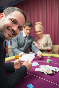 Man smiling while sitting at poker table