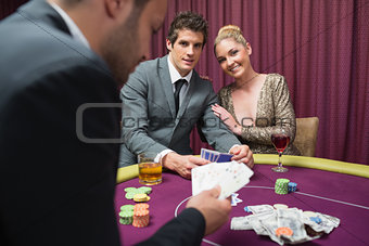 Couple playing poker and smiling