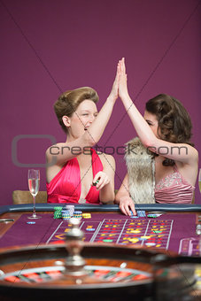 Women high fiving at roulette table