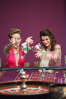 Women throwing chips on roulette table