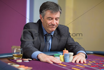 Man sitting at table looking at chips