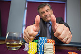 Man giving thumbs up sitting at roulette table