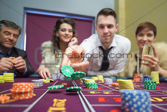 Man throwing chips down on roulette table