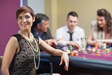Smiling woman taking break from roulette with champagne