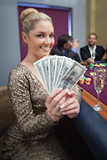 Blonde fanning dollars at roulette table