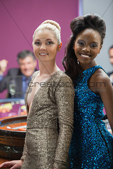 Two women standing beside roulette table