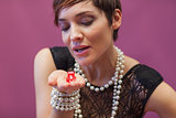 Woman blowing on dice for luck