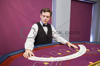 Dealer spreading deck of cards