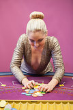 Woman in a casino grabbing chips