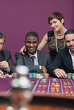 Three men and a woman at roulette table