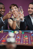 Three people toasting at roulette table