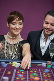 Woman placing roulette bet with man