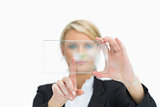 Blonde woman touching glass pane