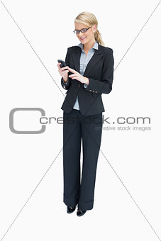 Businesswoman standing and using mobile phone