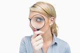 Businesswoman looking through magnifying glass